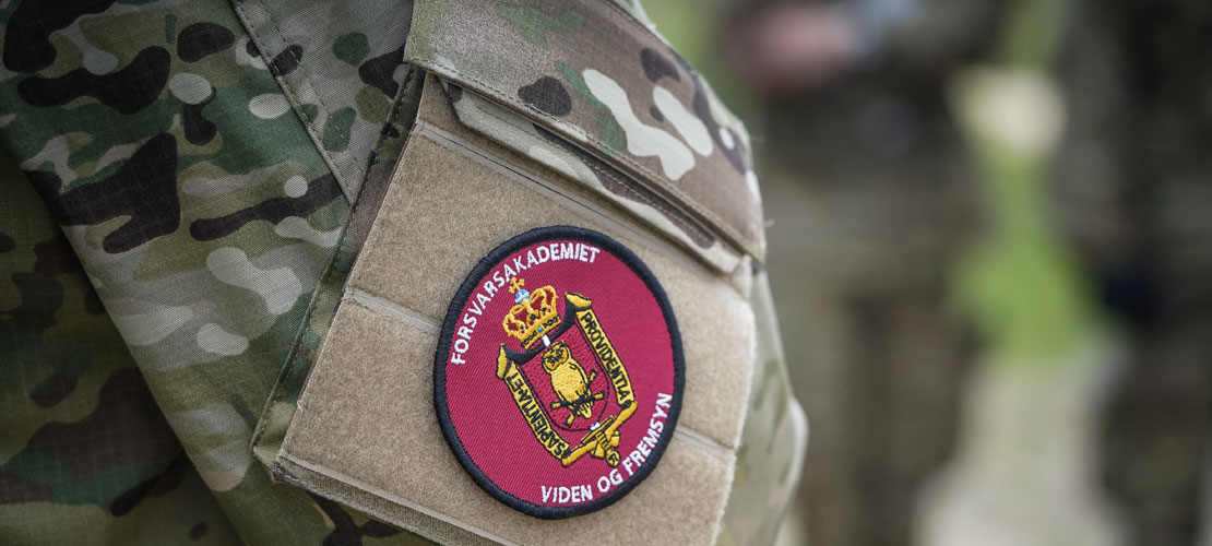 Nærbillede af en soldats arm og ærmemærke som er fra Forsvarsakademiet.
